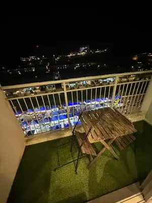 a wooden bench sitting on a balcony at night at AYAAN PENTHOUSE at Golden Hill Night Market View in Brinchang