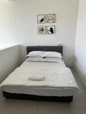 a bed with white sheets and pillows in a bedroom at AYAAN PENTHOUSE at Golden Hill Night Market View in Brinchang