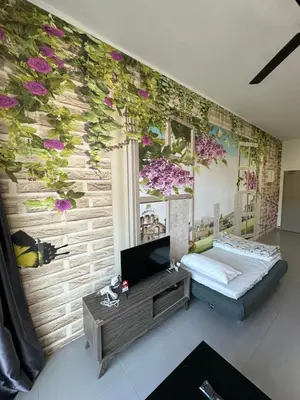 a living room with a wall with purple flowers at AYAAN Lavender Home at Golden Hills near Night Market in Brinchang