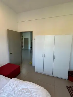 a bedroom with white cabinets and a red ottoman at AYAAN Lavender Home at Golden Hills near Night Market in Brinchang