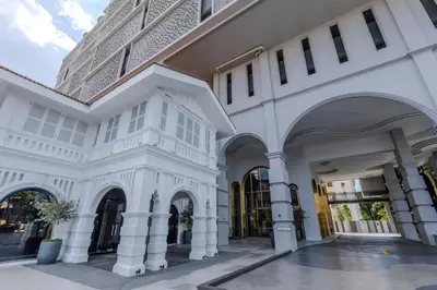 a white building with a tall building in the background at 22 Macalisterz in George Town