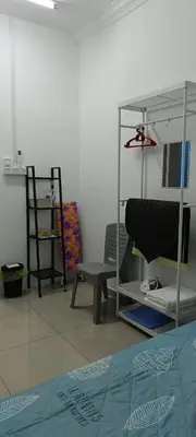 a room with a bed and a chair and shelves at Villa Atok Opah in Teluk Intan