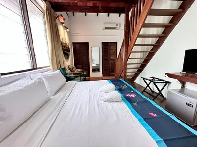 a large white bed in a room with stairs at Rangoon Residence 26 in George Town