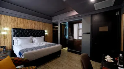 a hotel room with a bed and a living room at 1969 D'Kelly Hotel in Ipoh