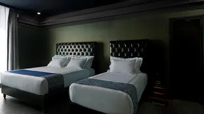 two beds sitting next to each other in a room at 1969 D'Kelly Hotel in Ipoh