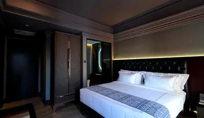 a bedroom with a large bed with a black headboard at 1969 D'Kelly Hotel in Ipoh