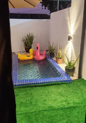 a pool with two inflatable toys in a backyard at Sun Rimba Home by Ipoh Maju Stay in Ipoh