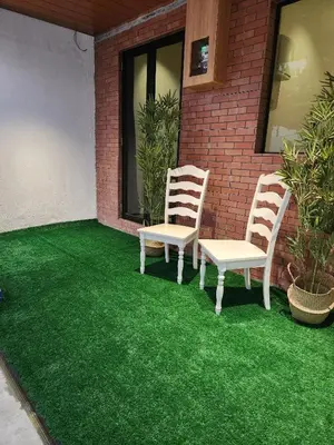 two chairs on a patio with green grass at Sun Rimba Home by Ipoh Maju Stay in Ipoh