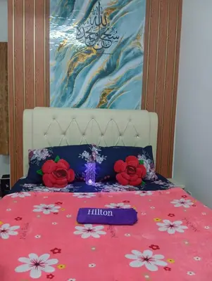 a bed with a bedspread with flowers on it at Auliya Homestay in Gua Sai