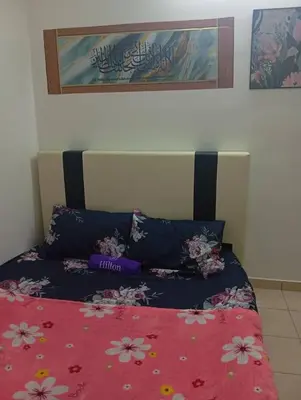 a bed with a red comforter with flowers on it at Auliya Homestay in Gua Sai