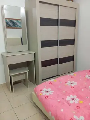 a bedroom with a bed and a dresser and a mirror at Auliya Homestay in Gua Sai