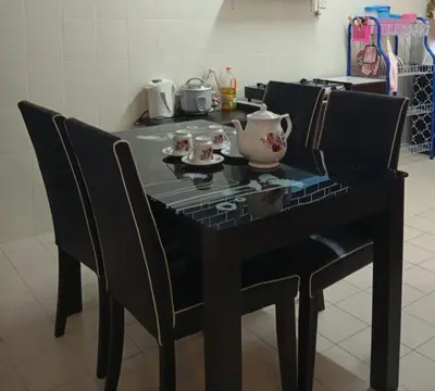 a black table with chairs and a tea pot on it at Auliya Homestay in Gua Sai