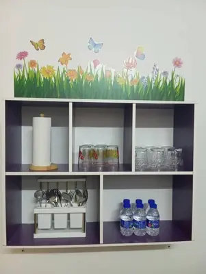 a shelf with bottles of water and flowers on it at Auliya Homestay in Gua Sai