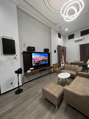 a living room with a couch and a flat screen tv at Eiffel Villa Homestay Melaka in Gua Sai
