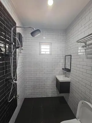a white bathroom with a sink and a shower at Eiffel Villa Homestay Melaka in Gua Sai