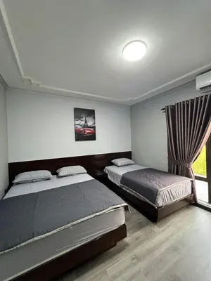 a bedroom with two beds and a window at Eiffel Villa Homestay Melaka in Gua Sai