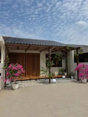 a small house with pink flowers in front of it at Shinju Villa with Jacuzzi Pool in Jelutong