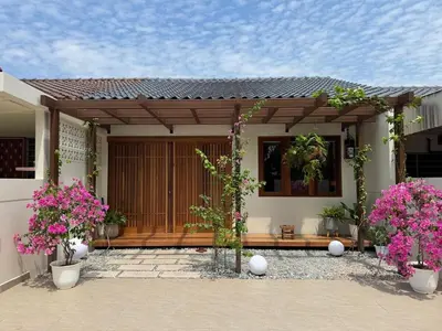 a porch of a house with pink flowers at Shinju Villa with Jacuzzi Pool in Jelutong