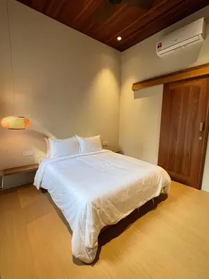 a bedroom with a white bed in a room at Shinju Villa with Jacuzzi Pool in Jelutong