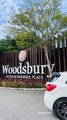 a white car parked in front of a wooden burrito sign at Woodsbury Suites Butterworth in Butterworth