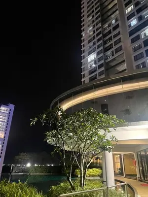 a building with a tree in front of it at night at Woodsbury Suites Butterworth in Butterworth