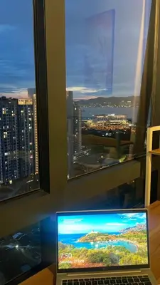 a laptop computer sitting on a desk in front of a window at Woodsbury Suites Butterworth in Butterworth