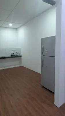 an empty room with a refrigerator and a wooden floor at Abadi's Homestay in Tanjung Karang