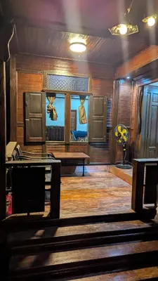 a room with a stage with a bench and a table at Abadi's Homestay in Tanjung Karang