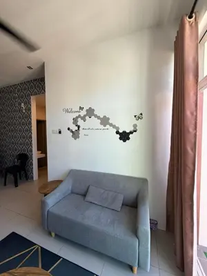 a living room with a blue couch and a wall at AYAAN AURORA at Golden Hill Near Night Market and Free Parking in Brinchang