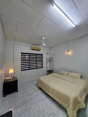 a bedroom with a large bed and a window at Teratak Abah in Seri Manjung