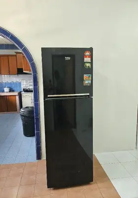 a black refrigerator in the middle of a kitchen at Teratak Abah in Seri Manjung