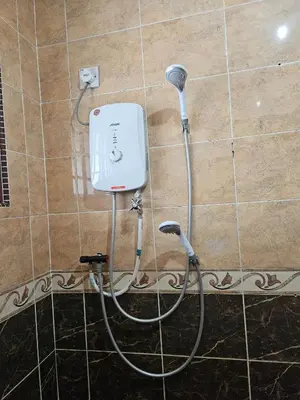a white hair dryer is attached to a wall at Teratak Abah in Seri Manjung
