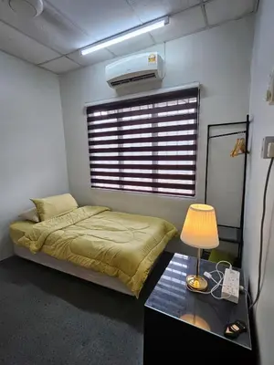 a bedroom with a bed and a table with a lamp at Teratak Abah in Seri Manjung