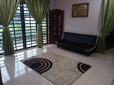 a living room with a black couch and a rug at Homestay Manjoi - muslim2 in Ipoh