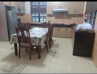 a kitchen with a table and chairs in a kitchen at Homestay Manjoi - muslim2 in Ipoh