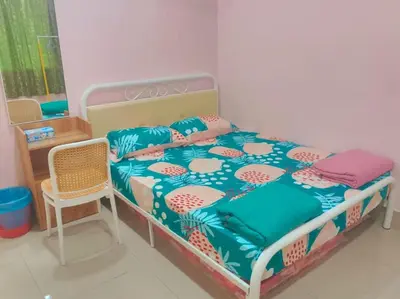 a bedroom with a bed and a chair at Cream Roof Homestay in Gua Sai