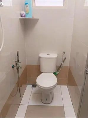 a bathroom with a white toilet and a shower at Cream Roof Homestay in Gua Sai