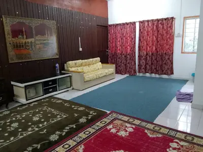 a living room with a couch and red curtains at Homestay Melati in Ipoh