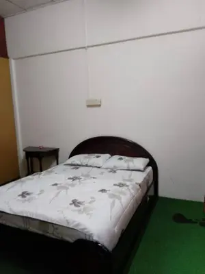 a bed in a room with a white wall at Homestay Melati in Ipoh