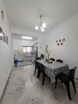 a dining room with a table and chairs and a kitchen at ACACIA GUESTHOUSE by Zamanja in Ipoh
