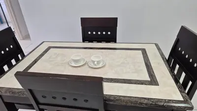a dining table with two cups and plates on it at Hide-out in Tanjong Tokong