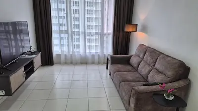 a living room with a couch and a television at Hide-out in Tanjong Tokong