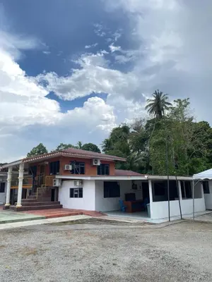 a building with a palm tree in the background at Villa Warisan Homestay