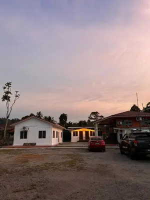 a group of buildings with cars parked in a parking lot at Villa Warisan Homestay