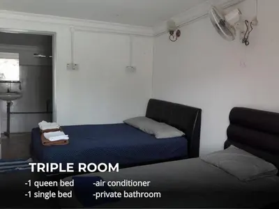 a bedroom with a bed and a single bed and a window at Villa Warisan Homestay