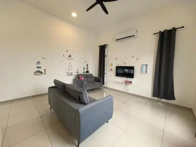 a living room with a couch and a tv at Padang Serai Wangi Homestay 95 in Padang Serai