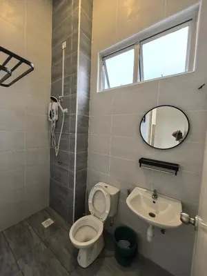 a bathroom with a toilet and a sink and a mirror at Padang Serai Wangi Homestay 95 in Padang Serai