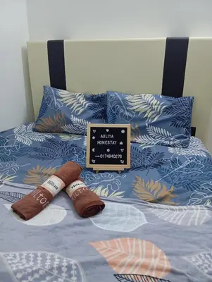 a bed with two slippers and a sign on it at Auliya homestay in Gua Sai