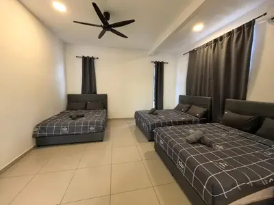 two beds in a room with a ceiling fan at Padang Serai Wangi Homestay 91 in Padang Serai