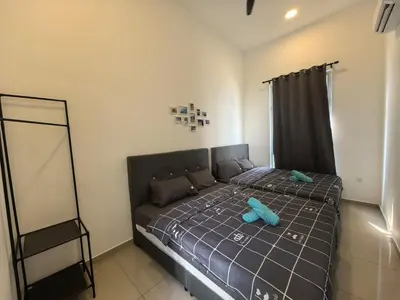 a bedroom with a bed with blue pillows at Padang Serai Wangi Homestay 91 in Padang Serai